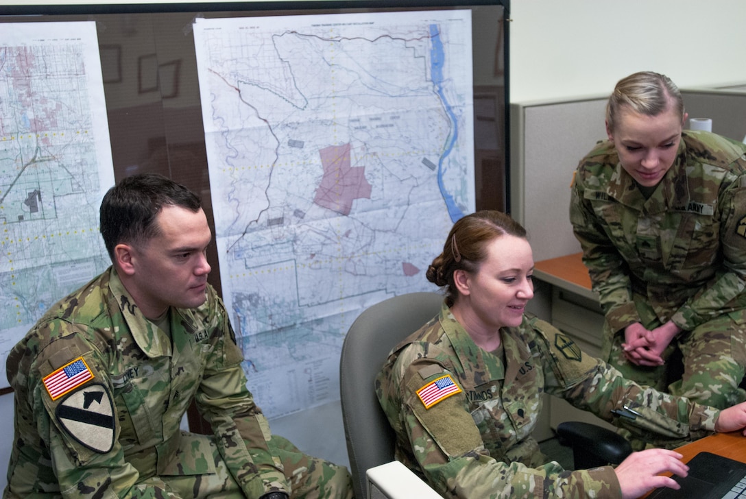 From left: Sgt. Morgan T. Wilken, Spc. Tara M. McTimmonds, Sgt. Noel A. Covey, work together to produce a Combined Obstacle Overlay, Joint Base Lewis-McChord, Wash. February 12, 2017. Geospatial engineers produce the maps that will support the commander’s next mission, and are a vital component of the Army, Army Reserve, and Total Force (U.S. Army Reserve photo by Spc. Sean Harding/Released).