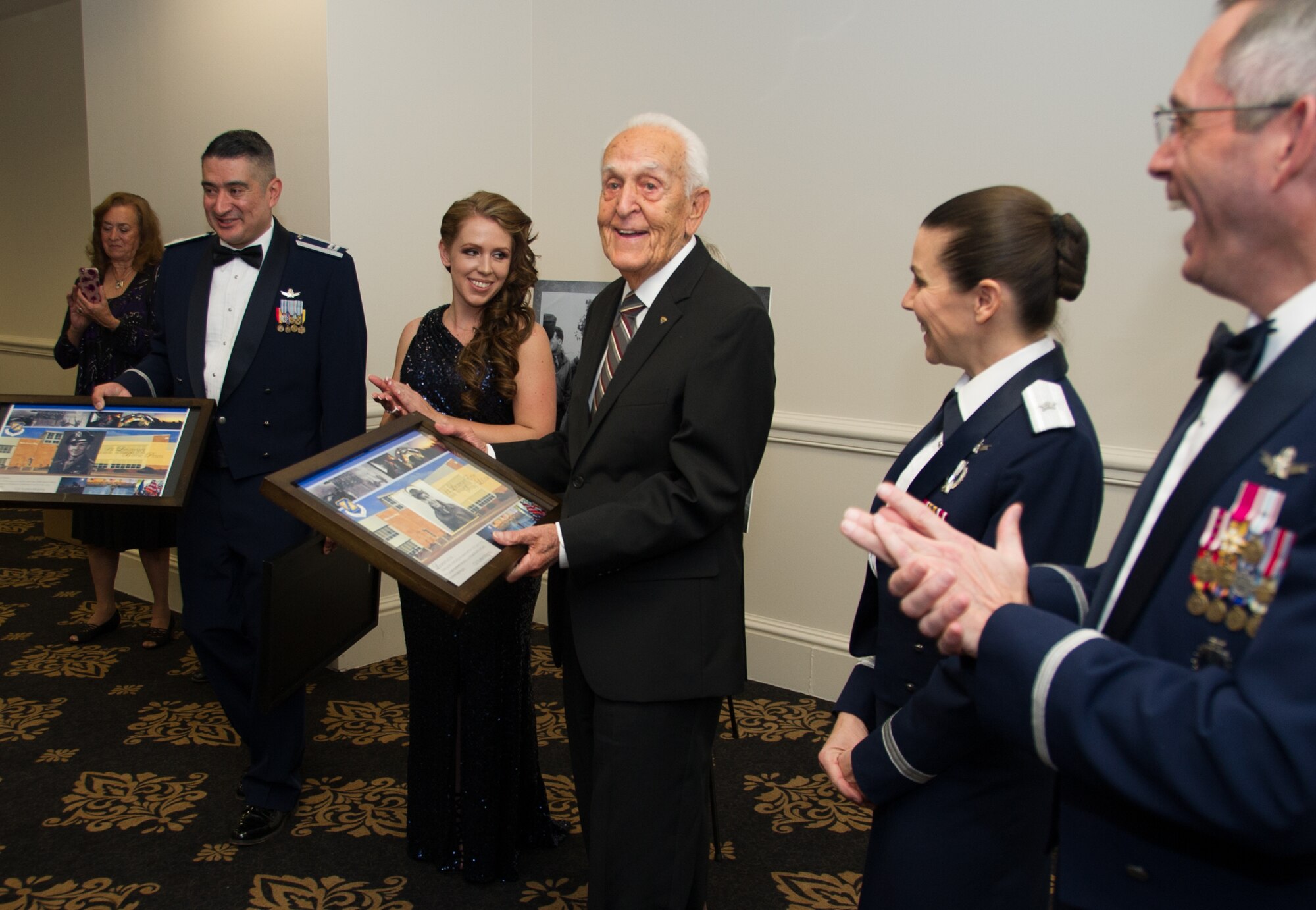 SCHRIEVER AIR FORCE BASE, Colo. -- 310th Bombardment Group alumni member, Lt. Ernest "Ernie" George LaCroix, Jr., is applauded after receiving a token of appreciation from Col. Traci Kueker-Murphy, 310th Space Wing commander, at the wing's 19th Annual Awards Banquet Saturday, Apr. 1st, 2017. The 310th Space Wing boasts a proud heritage that ties back to the Doolittle Raiders, who were members of the 310th Bombardment Group. (U.S. Air Force photo/Senior Airman Laura Turner)