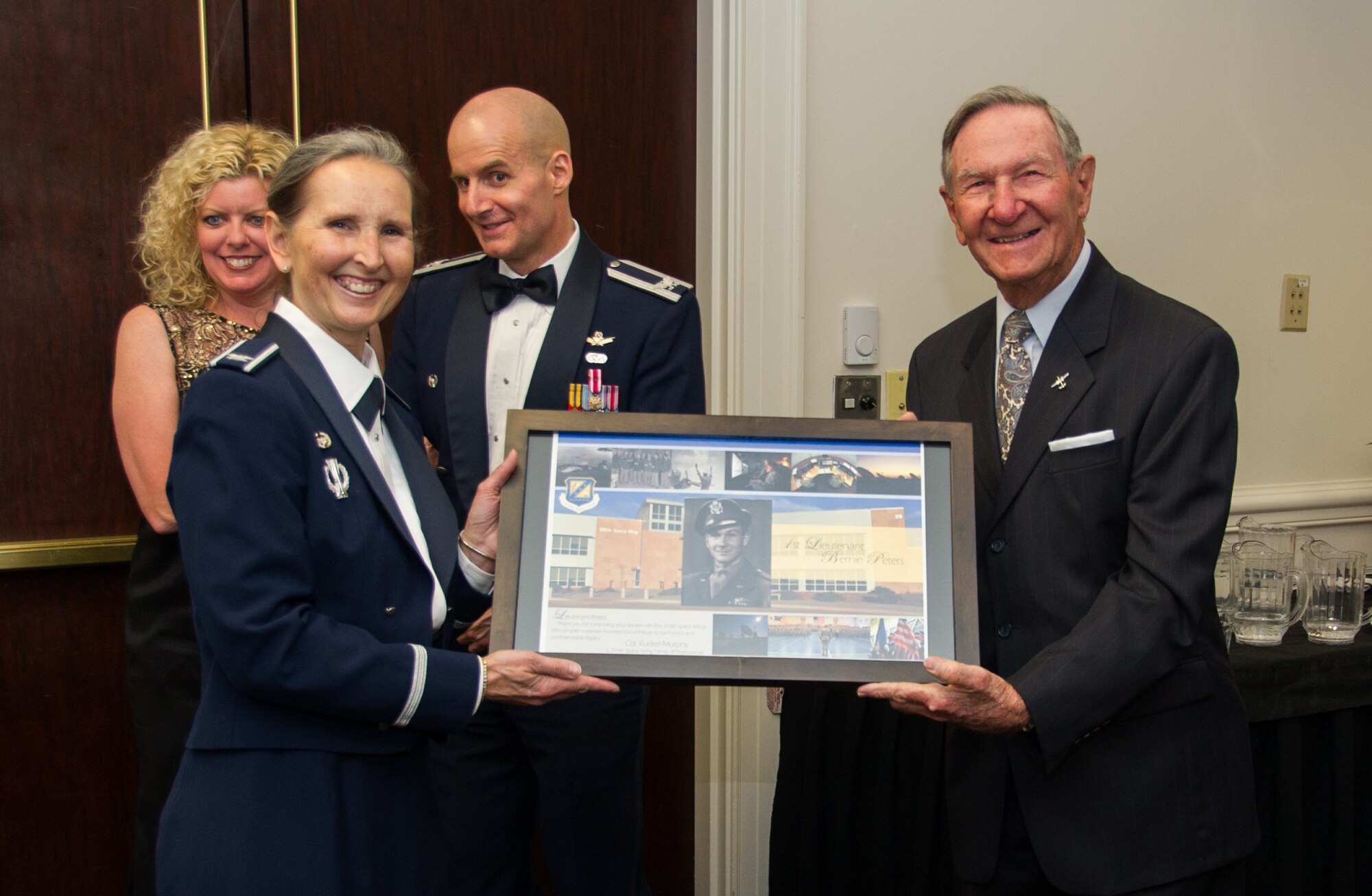 SCHRIEVER AIR FORCE BASE, Colo. -- 310th Bombardment Group alumni member, Lt. Bernard "Bernie" Peters accepts a token of appreciation from Col. Traci Kueker-Murphy, 310th Space Wing commander, at the wing's 19th Annual Awards Banquet Saturday, Apr. 1st, 2017. The 310th Space Wing boasts a proud heritage that ties back to the Doolittle Raiders, who were members of the 310th Bombardment Group. (U.S. Air Force photo/Senior Airman Laura Turner)