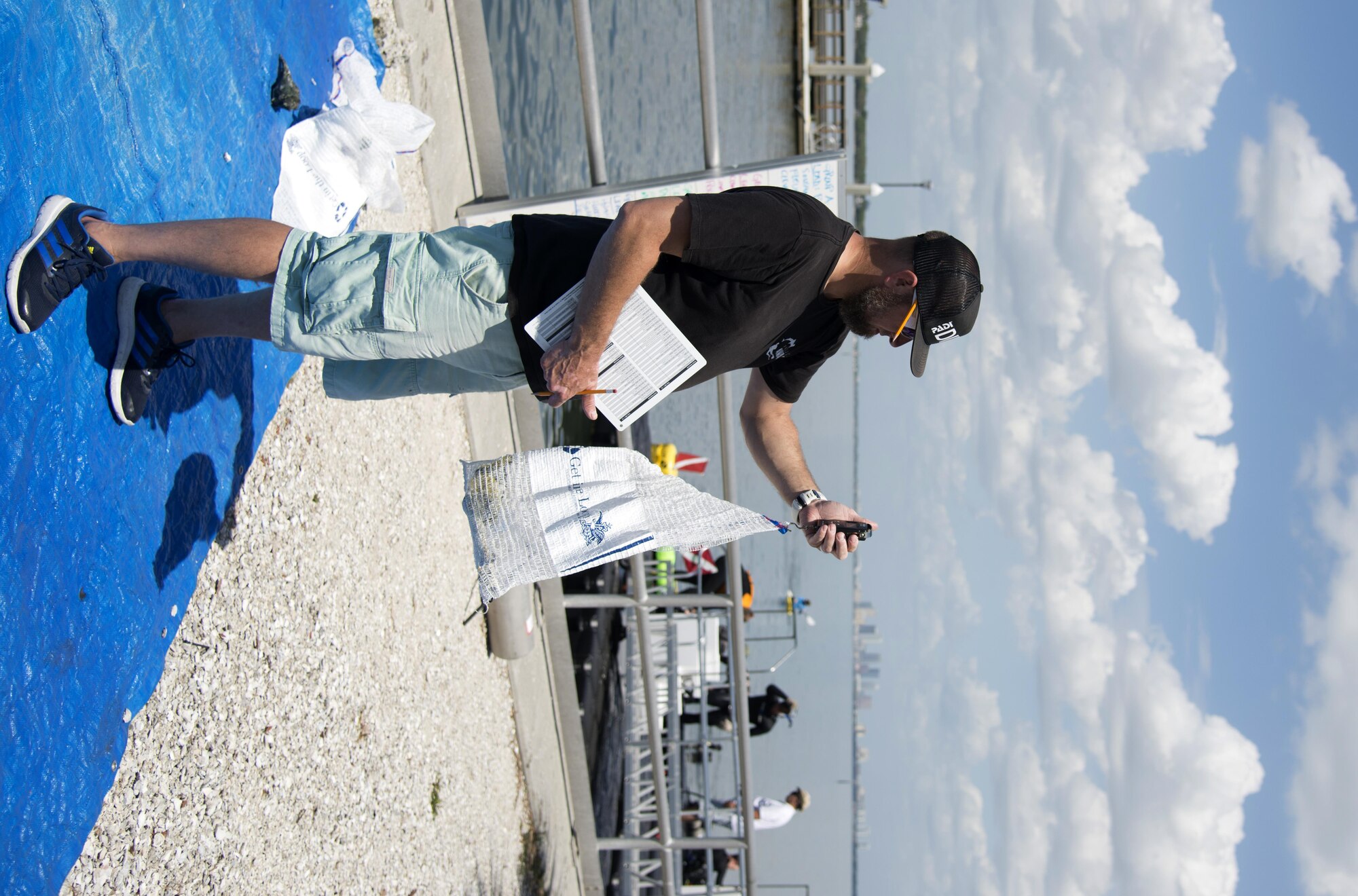 A volunteer weighs debris found in the water after the “Diving against Debris” event March 26, 2017 at MacDill Air Force Base, Fla. Divers filled bags with debris found in the water and then brought it to be weighed on shore before properly disposing it. (U.S. Air Force Photo by Airman 1st Class Rito Smith)