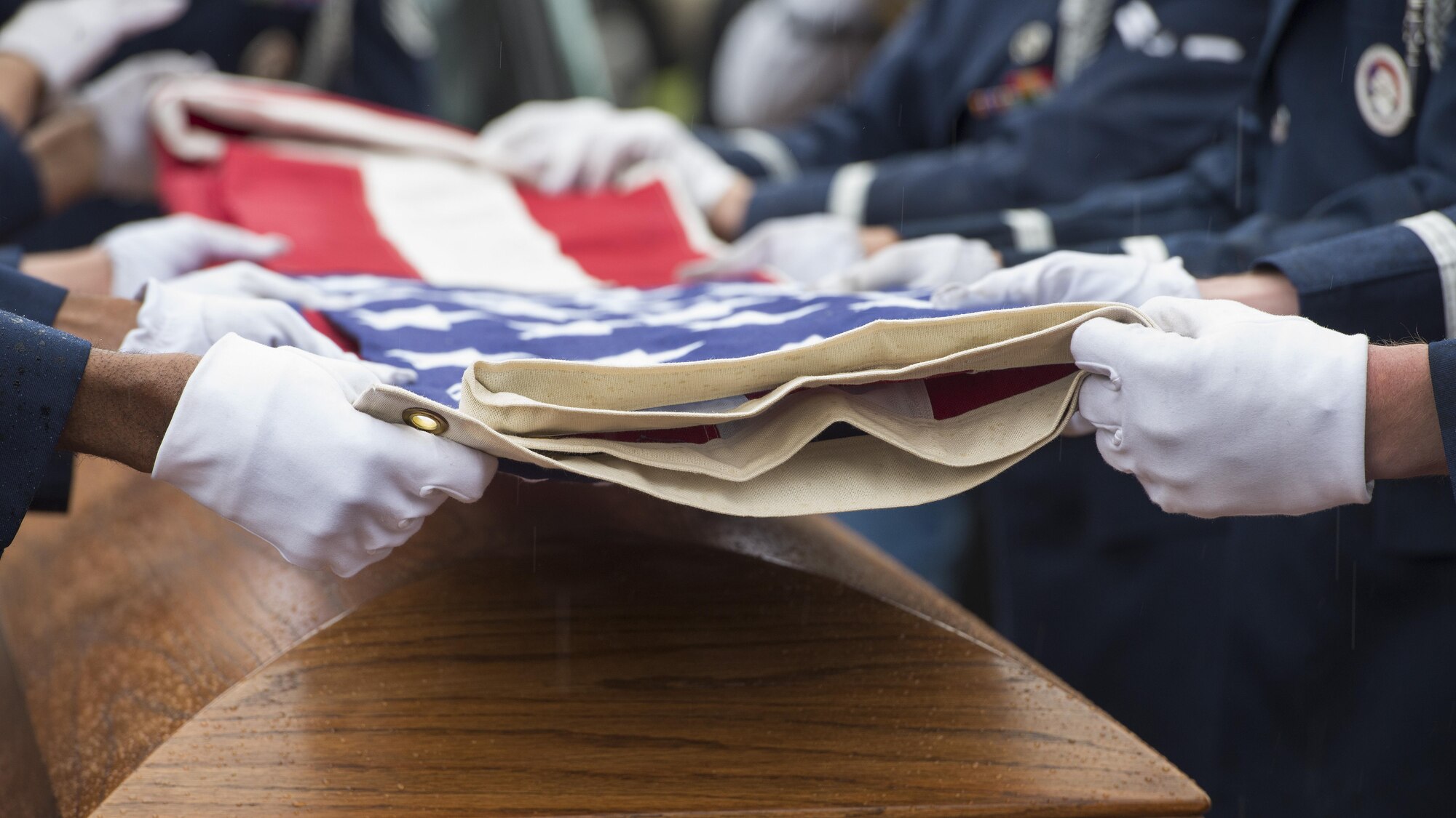 A Dover Air Force Base Honor Guard team folds an American flag during the funeral service of retired Maj. John L. Harrison, Jr., World War II veteran and Tuskegee Airman, March 31, 2017, at the Chapel of the Four Chaplains at the Navy Yard in Philadelphia, Pa. The Honor Guard team was comprised of eight Airmen. (U.S. Air Force photo by Senior Airman Zachary Cacicia)