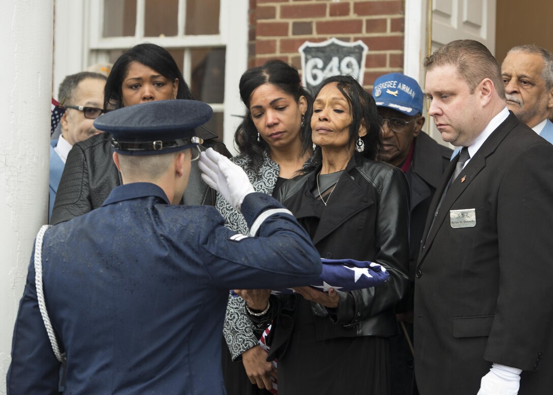 Airman 1st Class Joshua Ashe, Dover Air Force Base Honor Guard, salutes an American flag that was just presented to Joan Harrison, daughter of retired Maj. John L. Harrison, Jr., World War II veteran and Tuskegee Airman, during his funeral service March 31, 2017, at the Chapel of the Four Chaplains at the Navy Yard in Philadelphia, Pa. The flag is a symbol of appreciation for Maj. Harrison’s honorable and faithful service. (U.S. Air Force photo by Senior Airman Zachary Cacicia)