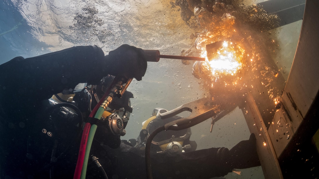 Navy Petty Officer 3rd Class Thomas Dahlke cuts a piece of steel in a training pool at the South Korean Naval Education and Training Command during exercise Foal Eagle in Jinhae, South Korea, March 31, 2017. Dahlke is an equipment operator assigned to Underwater Construction Team 2. The annual training exercise enhances the readiness of U.S. and South Korean forces and their ability to work together during a crisis. Navy photo by Chief Petty Officer Brett Cote