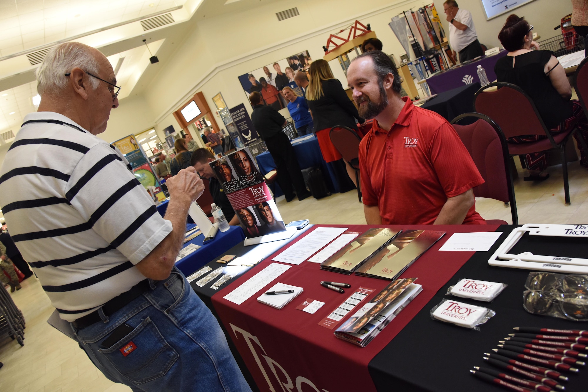 Rob Morrison, Troy University military and family representative and recruiter, provides information to retired Master Sgt. Dennis Roach during the Spring Education Information Fair at the base exchange, March 29, 2017, on Keesler Air Force Base, Miss. The Keesler Education Services’ staff hosted more than 25 community colleges and universities at the event. (U.S. Air Force photo by Kemberly Groue)