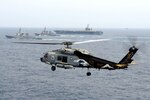 In this file photo, an SH-60F Seahawk helicopter, assigned to the Chargers of Helicopter Anti-Submarine Squadron (HS) 14, is airborne while the aircraft carrier USS George Washington (CVN 73), the Japan Maritime Self-Defense Force destroyer JS Kirishima (DD 174), and the Republic of Korea navy destroyer ROKS Sejong the Great (DDG 991) participate a trilateral event, June 22, 2012. The George Washington Carrier Strike Group is participating in a trilateral exercise to improve interoperability, readiness and the capability to respond quickly to various situations in the region with ships and aircraft from the Republic of Korea Navy and the Japan Maritime Self Defense Forces. 