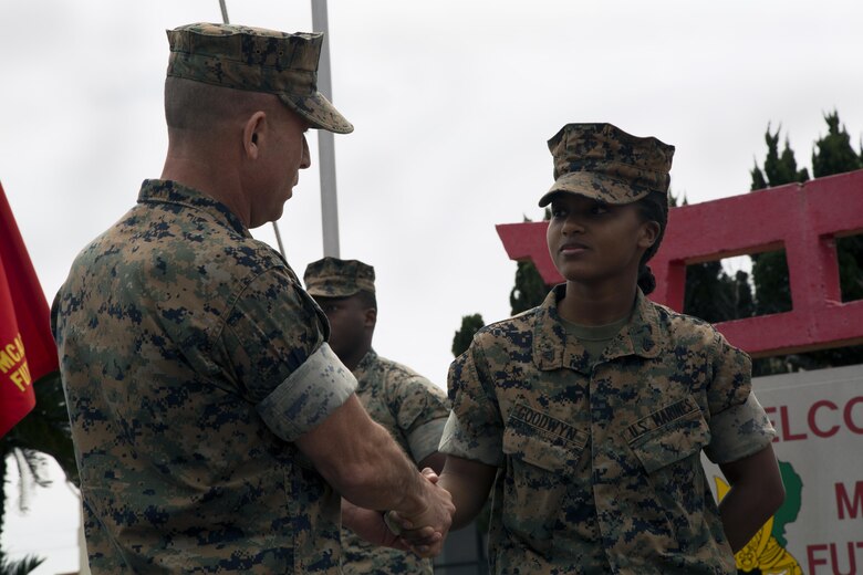 MCAS FUTENMA, OKINAWA, Japan— Maj. Gen. Malavet, left, gives a coin to Cpl. Alexis Goodwyn March 29 during an award ceremony on Marine Corps Air Station Futenma. During the ceremony, Headquarters and Headquarters Squadron received the 2016 National Defense Transportation Association Military Unit of the Year Award for their outstanding service in the field of transportation and logistics. H&HS went head-to-head against the other branches of service for this award and came out on top.  Malavet is the commanding general for Marine Corps Installations Pacific and Marine Corps Base Camp Butler-Japan. Goodwyn is the operations chief for H&HS, MCAS Futenma, Marine Corps Installations Pacific. (U.S. Marine Corps photo by Cpl. Jessica Collins)