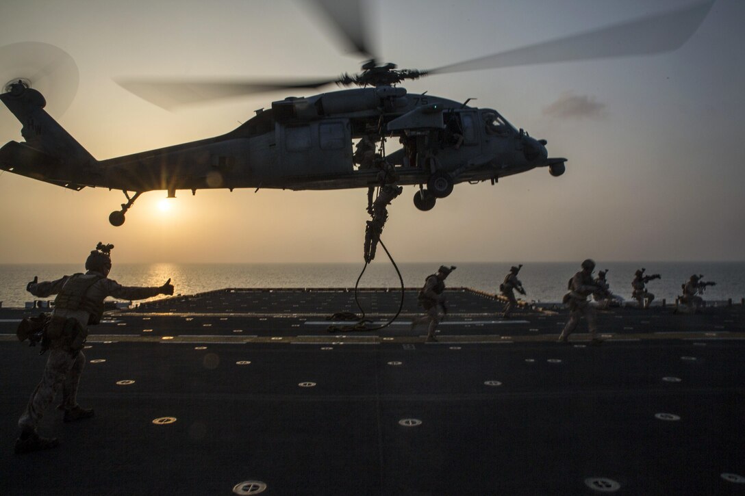 Marines fast-rope out of an SH-60 Seahawk during an exercise on the USS Bataan at sea, March 29, 2017. The Marines are assigned to the Maritime Raid Force, 24th Marine Expeditionary Unit, which trains regularly to stay mission capable while deployed. The Bataan is supporting maritime security operations and theater security cooperation efforts in the 5th Fleet area of operation. Marine Corps photo by Cpl. Brianna Gaudi