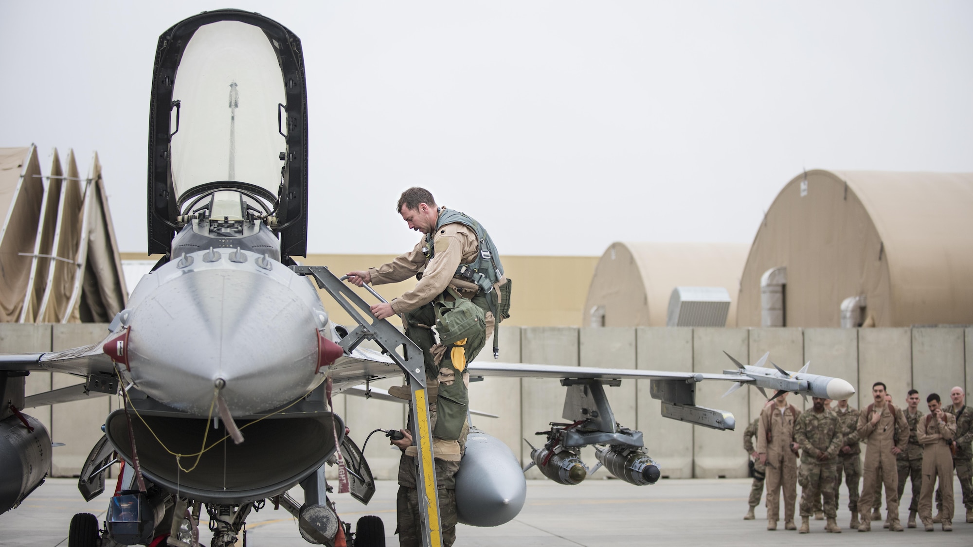 Lt. Col. Craig Andrle, 79th Expeditionary Fighter Squadron commander, climbs down from an F-16 Fighting Falcon as members of the 79th EFS wait to congratulate him on flying his 1,000th combat hour March 20, 2017 at Bagram Airfield, Afghanistan. Andrle reached the milestone while supporting the wing’s counterterrorism mission in Afghanistan. (U.S. Air Force photo by Staff Sgt. Katherine Spessa)