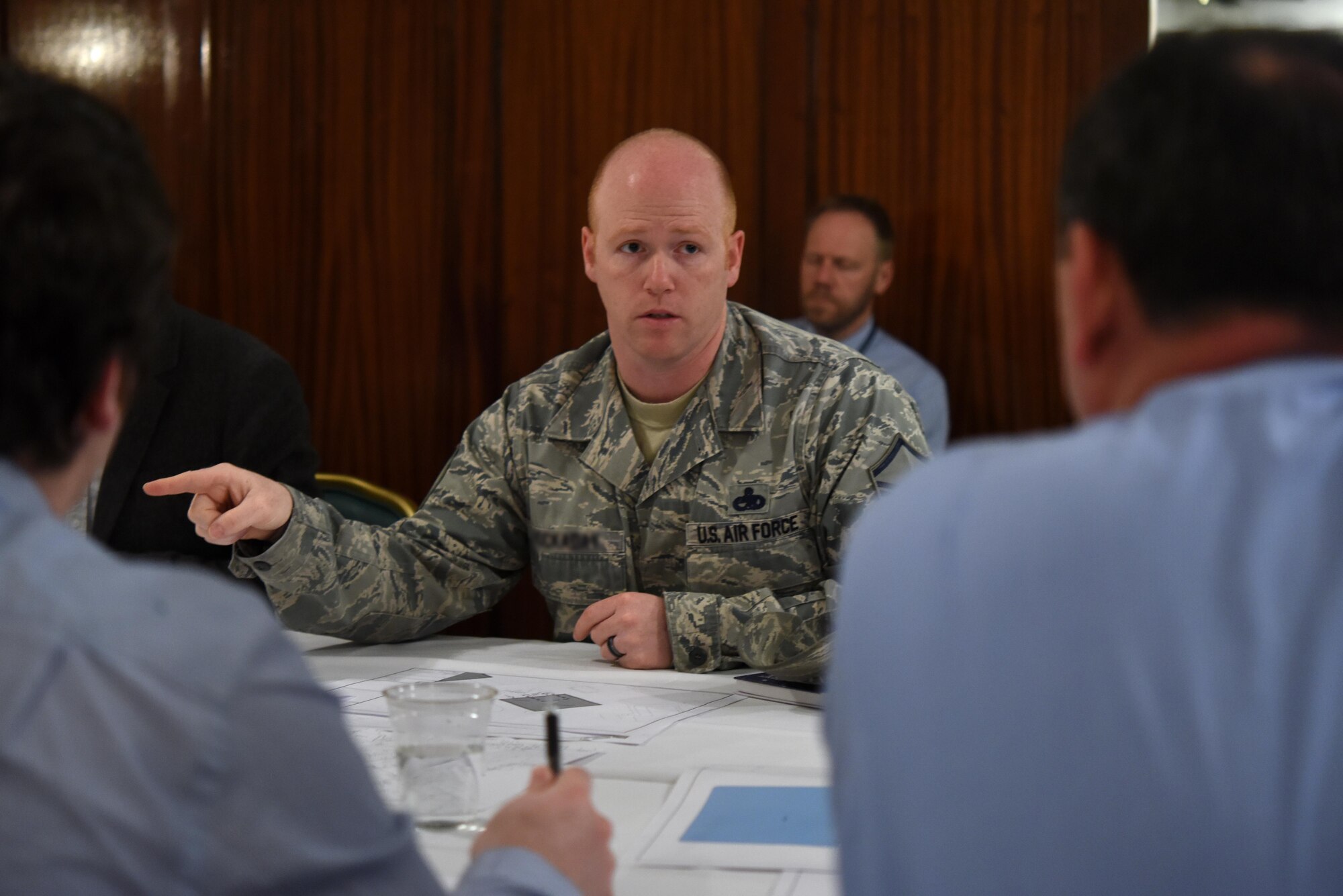 An Airman assigned to the 48th Fighter Wing discusses F-35 Lightning II building requirements with contractors at Royal Air Force Lakenheath, England, March 22, 2017. The F-35 is slated to arrive at RAF Lakenheath in 2021. (U.S. Air Force photo/Airman 1st Class Eli Chevalier)