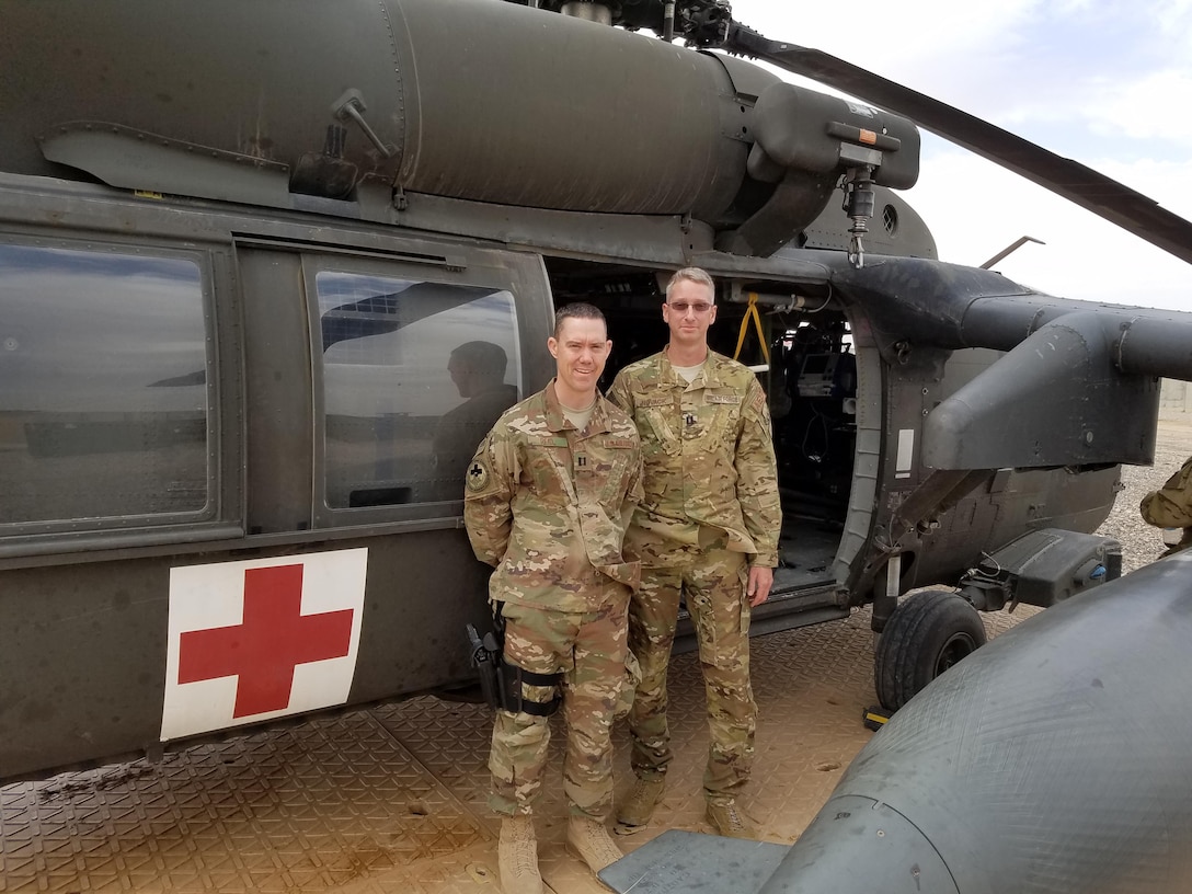 U.S. Air Force Capt. Jonathan Reid, left, and U.S. Air Force Capt. Christopher Novack, both aeromedical evacuation liaison officers with the 379th Expeditionary Aeromedical Evacuation Squadron, pose for a photo in front of a medical evacuation helicopter after a patient movement training session at Qayyarah West Airfield, Iraq, March 28, 2017. The liaison officers from Al Udeid Air Base, Qatar, instructed patient movement procedures to U.S. Navy medical personnel. (Courtesy photo)