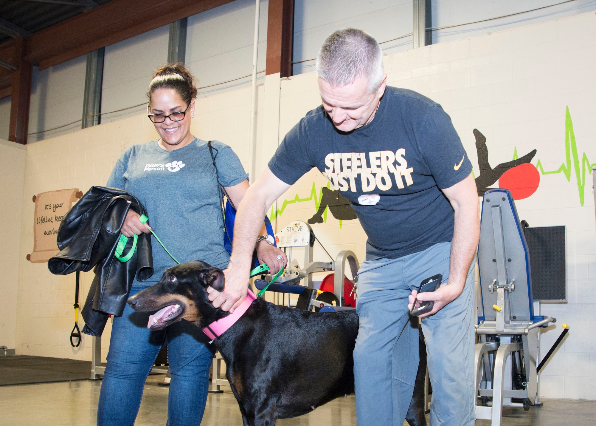 Bill Zwicharowski, Air Force Mortuary Affairs Operations port mortuary branch chief, pets “Angel,” a PAWS for People dog, during a visit from PAWS for People March 28, 2017, at AFMAO on Dover Air Force Base, Del. “Angel” and her owner, Gennette Washington, are a part of a nonprofit organization which provides elders, children, and people with disabilities individualized, therapeutic visits with gentle, affectionate pets. These pets undergoing rigorous training and testing.  (U.S. Air Force photo by Staff Sgt. Jared Duhon)