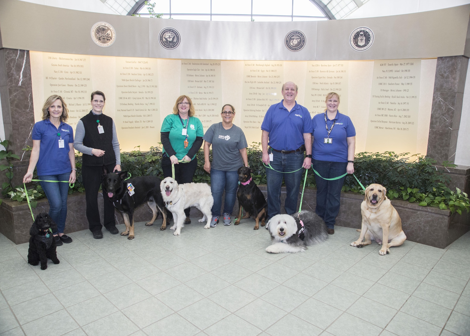 PAWS for People volunteers pose with their pooches March 28, 2017, at Air Force Mortuary Affairs Operations on Dover Air Force Base, Del. PAWs for People is a nonprofit organization committed to providing therapeutic visits to the community. Volunteers usually have dogs, but can sometimes have cats or bunnies. (U.S. Air Force photo by Staff Sgt. Jared Duhon)