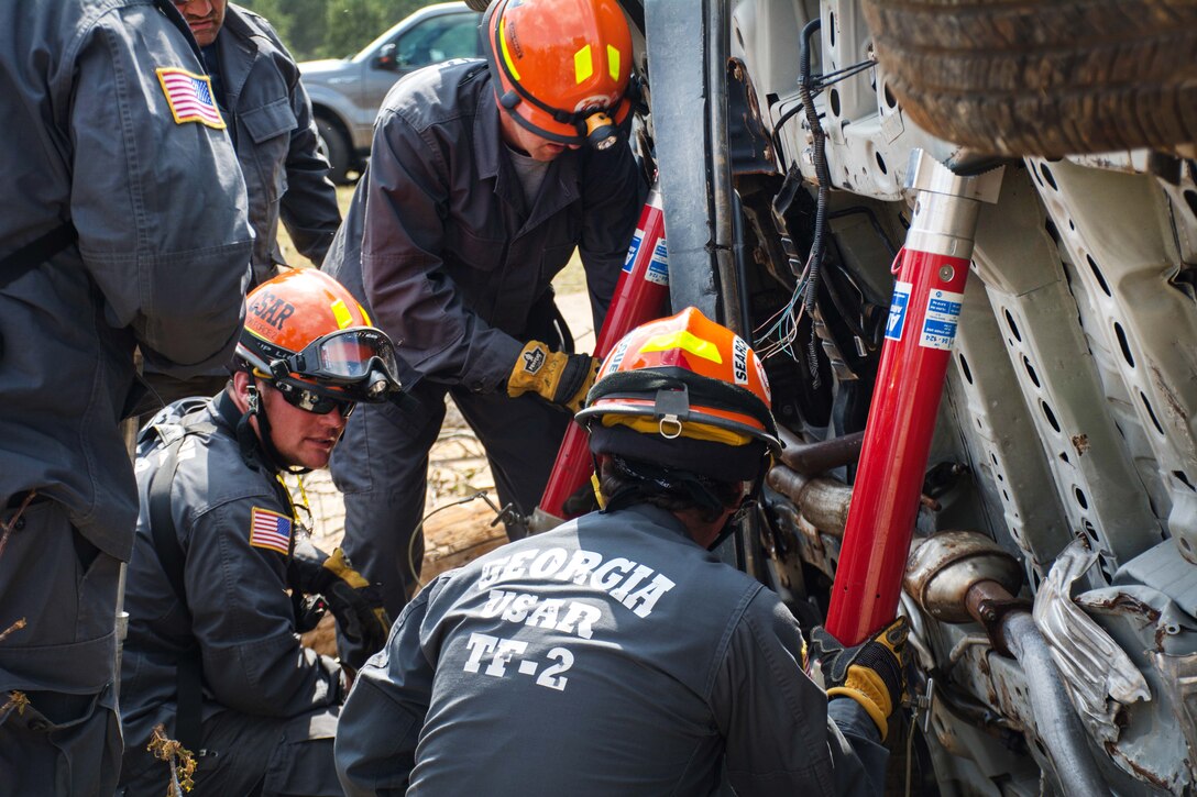 Members of the Georgia Search and Rescue Task Force 2 stabilize a vehicle that had been in a mock accident during Operation Vigilant Guard at the Guardian Center in Perry, Georgia, March 29, 2017. Army photo by Pfc. Darion Gibson