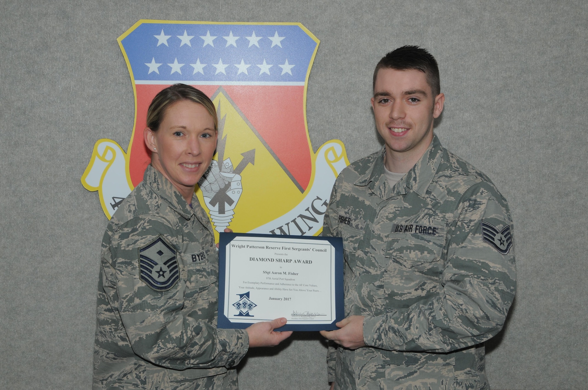 Master Sgt. Ashely Byers, 14th Intelligence Squadron first sergeant, presents the Diamond Sharp Award to Staff Sgt. Aaron Fisher, 87th Aerial Port Squadron, March 4, 2017. The award is given for exemplary performance and adherence to the Air Force Core Values, attitude and appearance. (U.S. air Force photo/Tech. Sgt. Anthony Springer)