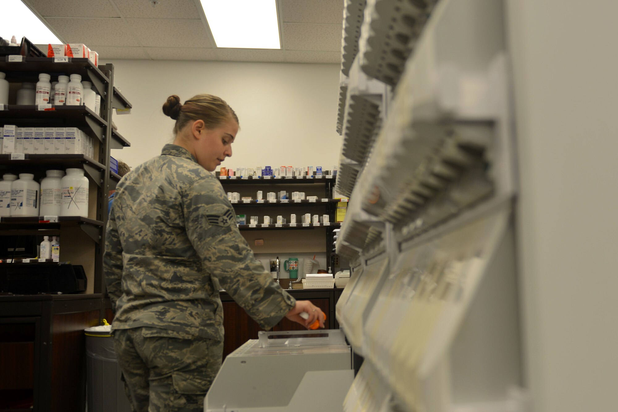 U.S. Air Force Senior Airman Payton Nester-Wooton, 20th Medical Support Squadron pharmacy technician, refills an automated filling machine at Shaw Air Force Base, S.C., March 29, 2017. The automated filling machine allows pharmacy technicians to quickly fill pill bottles with the correct amount of medication. (U.S. Air Force photo by Airman 1st Class Destinee Sweeney)