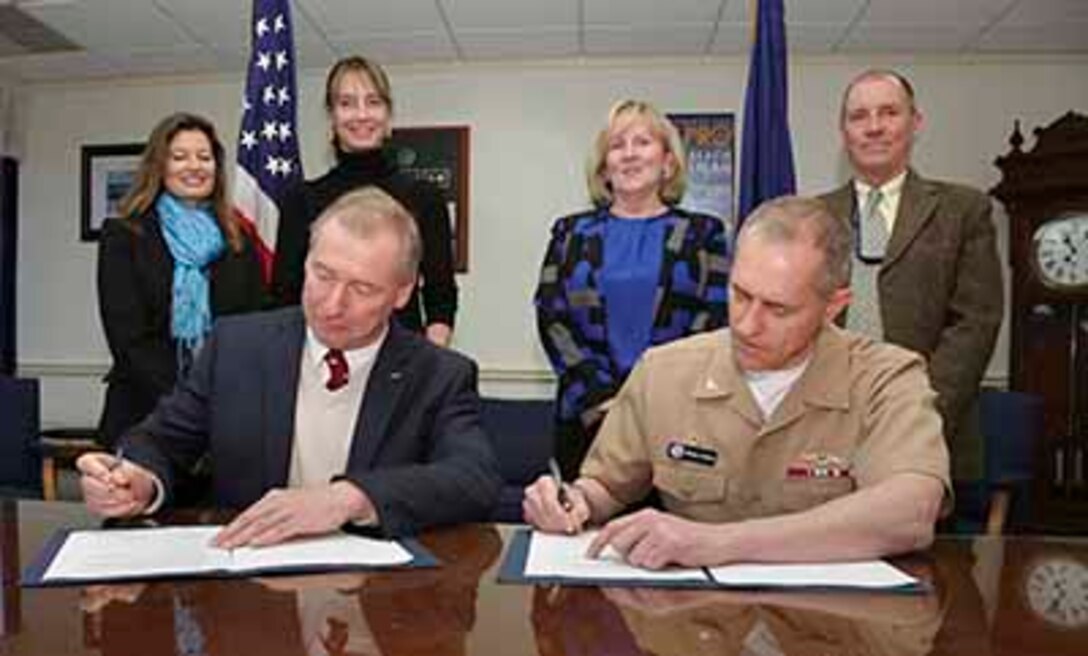 James Russell, president and CEO of the New Bedford Whaling Museum  and Capt. Michael Coughlin, NUWC Division Newport commanding officer, sign an Education Partnership Agreement for undersea acoustic research on March 31. Looking on are NUWC Division Newport marine mammal biologist Monica DeAngelis (from left); Christina Connett, New Bedford Whaling Museum curator of Exhibitions & Collections; NUWC Division Newport Technical Director Mary Wohlgemuth; and NUWC Division Newport marine biologist Thomas Fetherston.