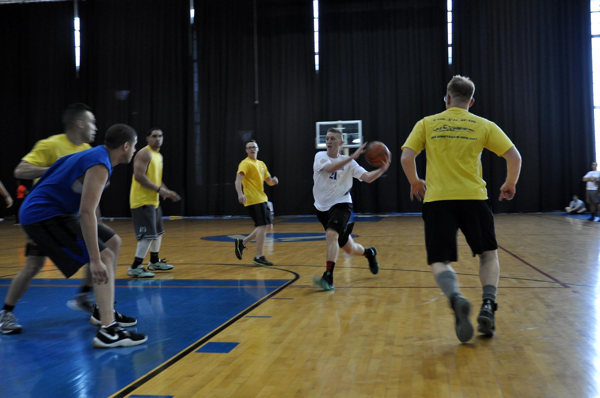 Tech. Sgt. David Richards, 87th Aerial Port Squadron, charges the basket before hurtling the ball to a teammate during the first game of  the March Mania Basketball Tournament. The LRS ultimately walked away as champions of the event, having played in, and won, three out of the four games. (U.S. Air Force photo/Staff Sgt. Rachel Ingram)