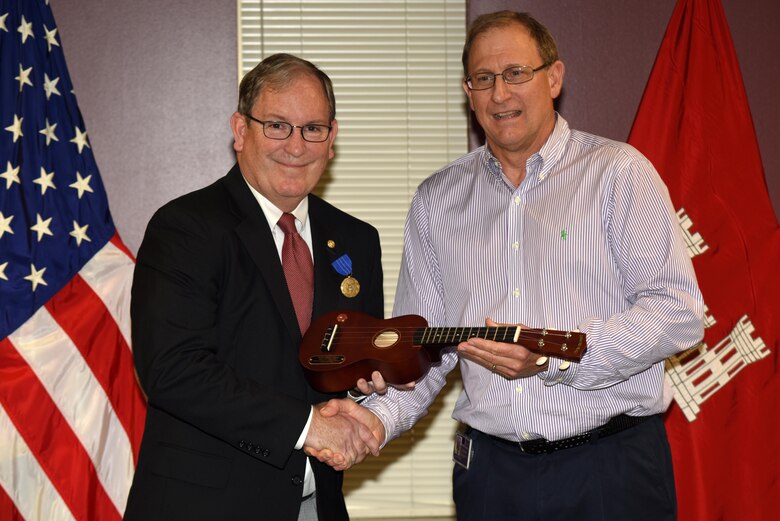 Jimmy Waddle (Right), U.S. Army Corps of Engineers Nashville District Engineering and Construction Division chief, presents a ukulele on behalf of senior leaders to Mike Wilson, Nashville District deputy for Programs and Project Management, honoring his 42 years of federal service during a retirement ceremony at the district headquarters in Nashville, Tenn., March 31, 2017. 