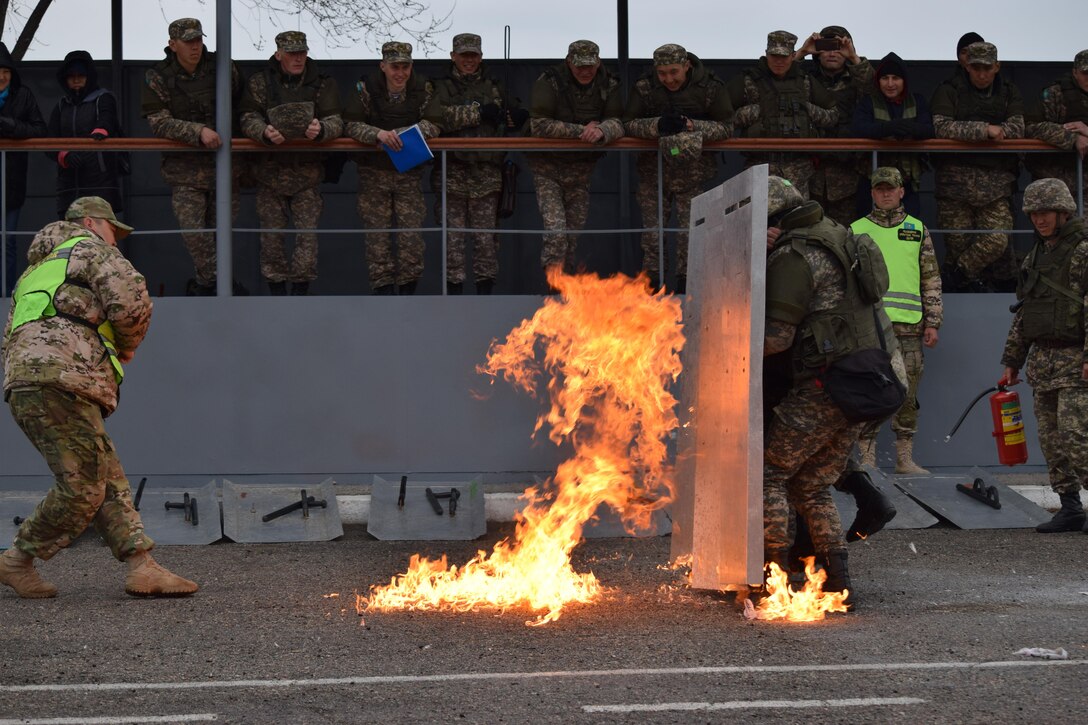 A Kazakhstani instructor for the Kazakhstan Peacekeeping Battalion demonstrates how to react to a petrol bomb when conducting crowd control operations Apr. 1, 2017, during phase one of Exercise Steppe Eagle at Illisky Training Center, Kazakhstan.