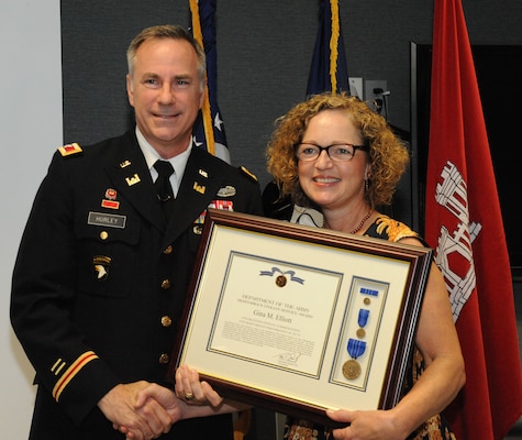 Col. John Hurley, Huntsville Center commander, presents Gina Elliott with a Meritorious Civilian Service Award during Elliott's retirement ceremony March 31. Elliott served as Huntsville Center deputy commander for four months in 2014 and most recently served as Huntsville Center's Facilities Division chief. Elliott retires from the U.S. Army Corps of Engineers with 37 years of service.