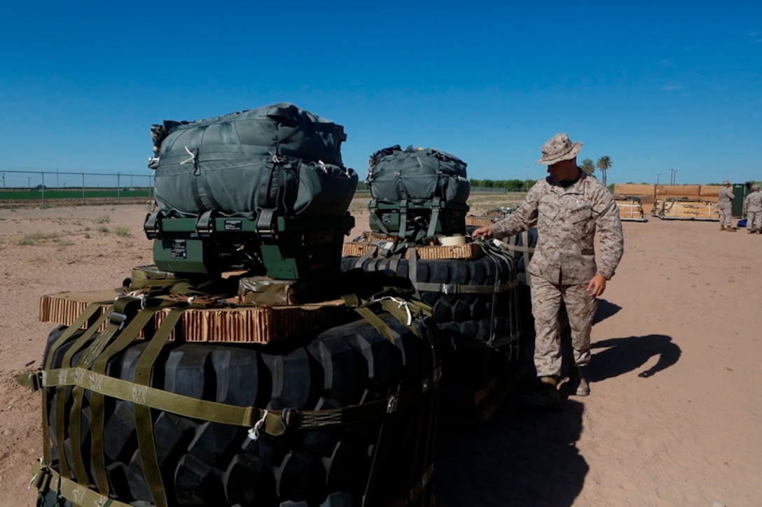 U.S Marine Pfc. Brad A. Clark inspects the rigged aerial delivery systems of Joint Precision Airdrops during a Weapons and Training Instructor Course March 30, 2017, at Marine Corps Air Station Yuma, Ariz. Clark is an airborne delivery specialist with 2nd Transportation Support Battalion, 2nd Marine Logistics Group. The JPADS uses a GPS system and a modular autonomous guidance unit to get to their targeted drop zones.
