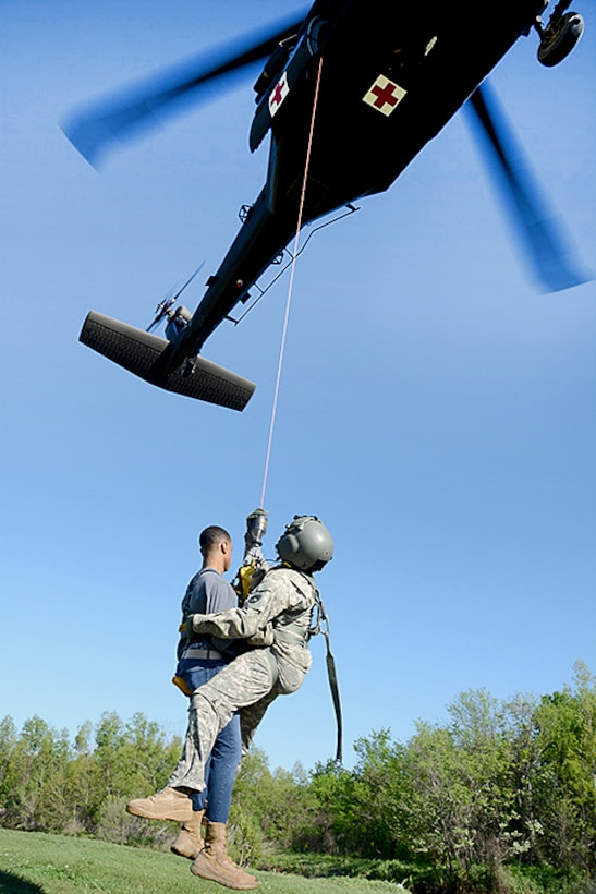 A UH-60 Black Hawk helicopter hoists a Louisiana Army National Guard member and a mock casualty during a disaster relief exercise at the Bonnet Carre Spillway, St. Charles Parish, Louisiana, April 1, 2017. Army National Guard photo by 1st Sgt. Paul Meeker