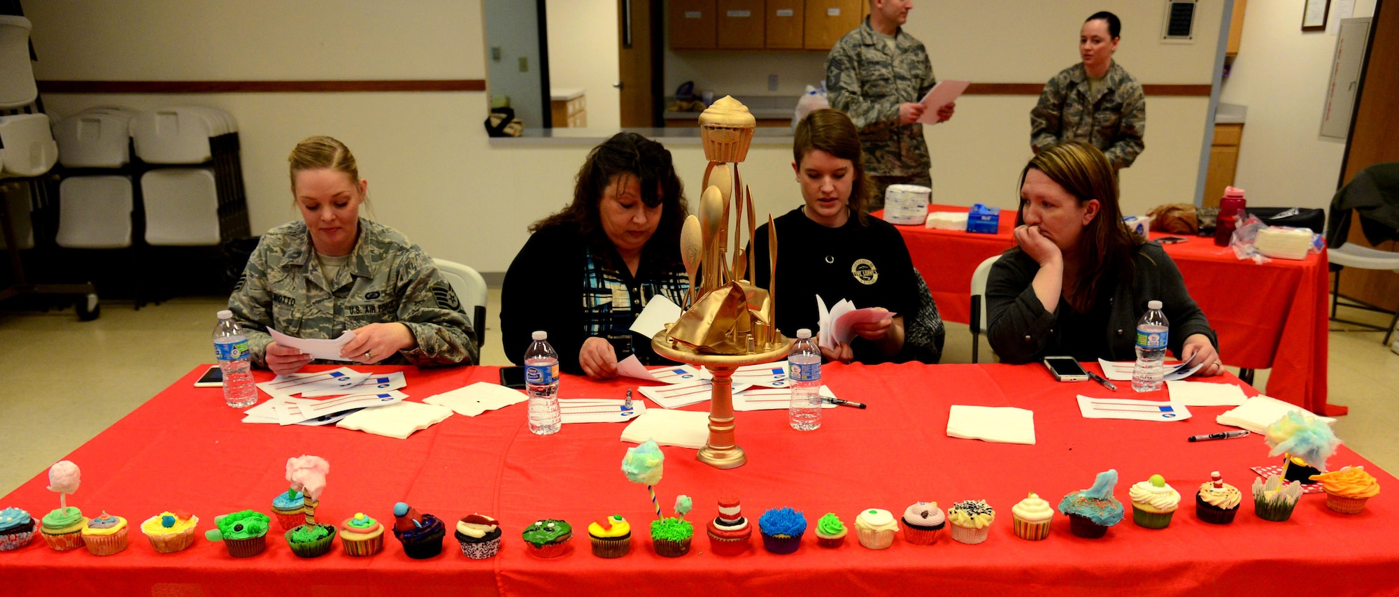 Judges discusses competition results at the 341st Missile Wing’s first cupcake war held April 3, 2017, at Malmstrom Air Force Base, Mont. Four judges tasted quartered bits of 26 different cupcake recipes submitted by 18 different teams, judging taste and creativity. (U.S. Air Force photo/Senior Airman Magen M. Reeves)