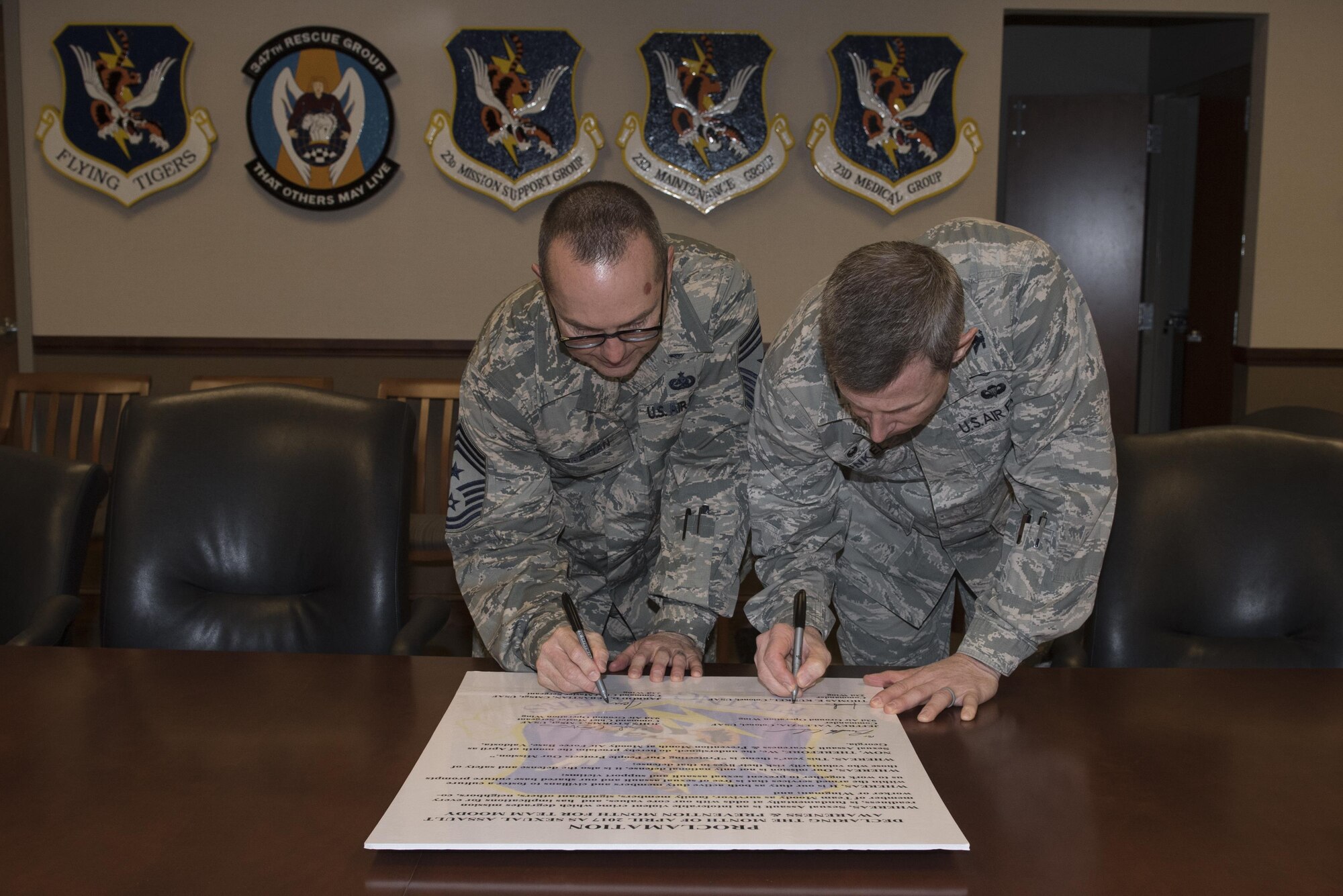 Chief Master Sgt. Jarrod Sebastian, 23d Wing command chief, left, and Col. Thomas Kunkel, 23d Wing commander, sign a proclamation, March 20, 2017, at Moody Air Force Base, Ga. The proclamation was signed to declare the month of April 2017 as Sexual Assault Prevention and Response month for Team Moody. This year’s theme for SAPR month is “Protecting our people protects our mission.” (U.S. Air Force photo by Airman 1st Class Lauren M. Sprunk)