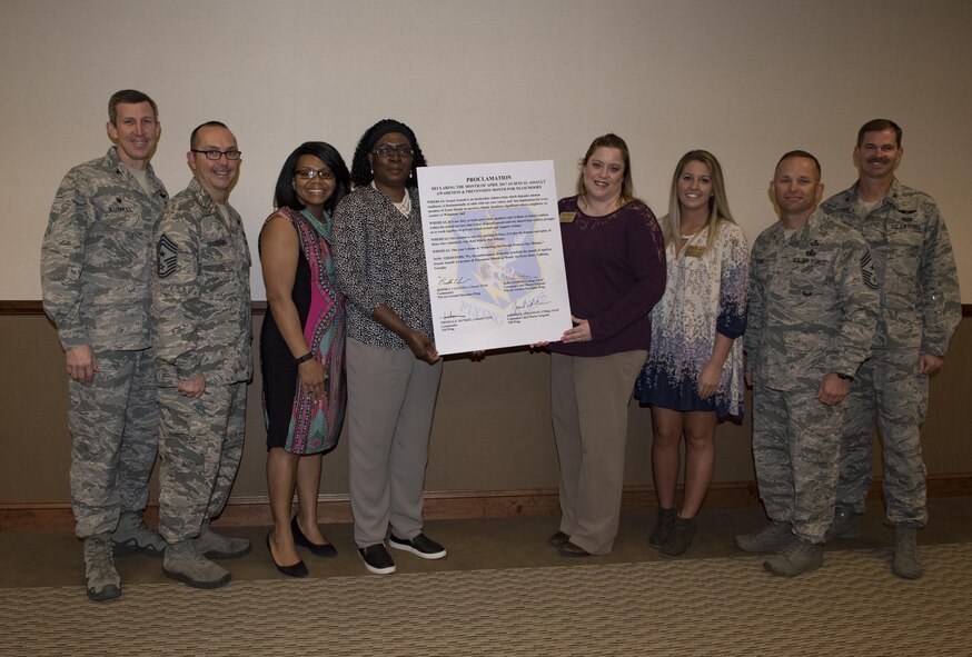 Members from the Sexual Assault Prevention and Response program and base leadership pose for a photo with a proclamation, March 20, 2017, at Moody Air Force Base, Ga. The proclamation was signed to declare the month of April 2017 as SAPR month for Team Moody. This year’s theme for SAPR month is “Protecting our people protects our mission.” (U.S. Air Force photo by Airman 1st Class Lauren M. Sprunk)