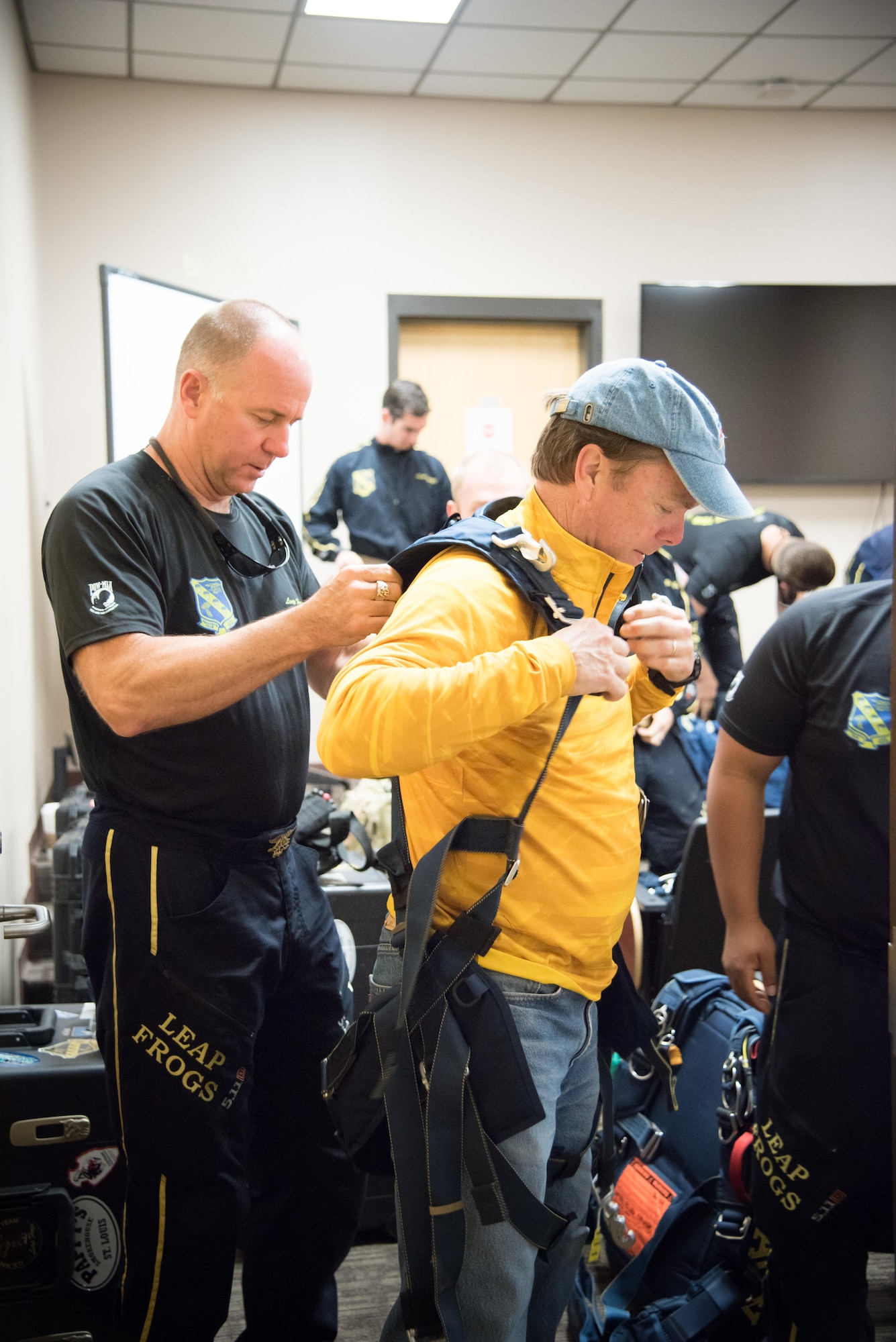 A member of the U.S. Navy Leap Frogs helps Gulfport Mayor Billy Hewes into a harness before boarding an 815th Airlift Squadron C-130J Super Hercules aircraft for a jump April 4 out of Keesler Air Force Base, Mississippi. The Leap Frogs coordinated with the Flying Jennies to complete this jump and several others as joint training for both groups, which was also in conjunction with Navy Week and the Mississippi bicentennial celebration. (U.S. Air Force photo/Staff Sgt. Heather Heiney)