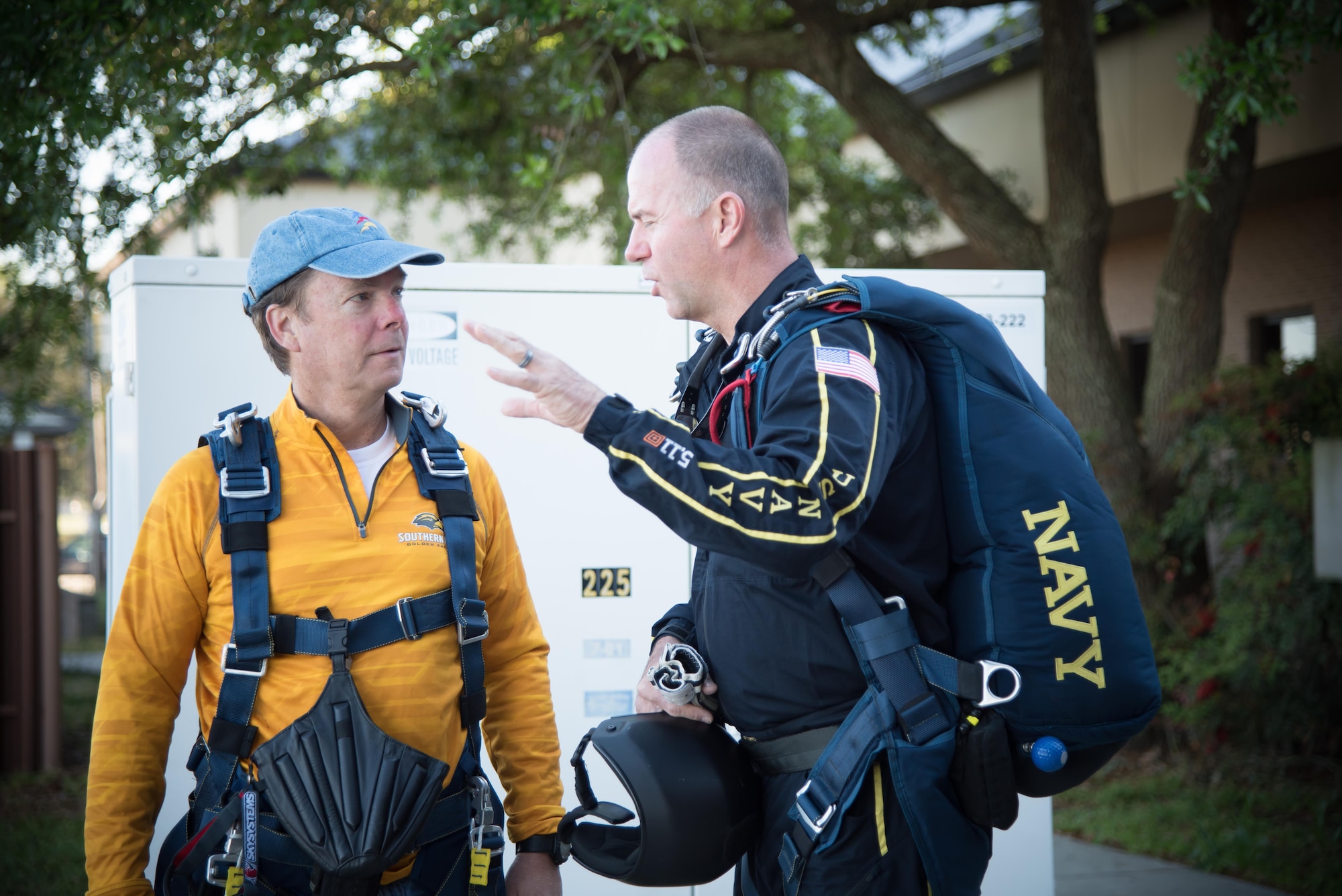 A member of the U.S. Navy Leap Frogs explains tandem jump procedures to Gulfport Mayor Billy Hewes before boarding an 815th Airlift Squadron C-130J Super Hercules aircraft for a jump April 4 out of Keesler Air Force Base, Mississippi. The Leap Frogs coordinated with the Flying Jennies to complete this jump and several others as joint training for both groups, which was also in conjunction with Navy Week and the Mississippi bicentennial celebration.(U.S. Air Force photo/Staff Sgt. Heather Heiney)