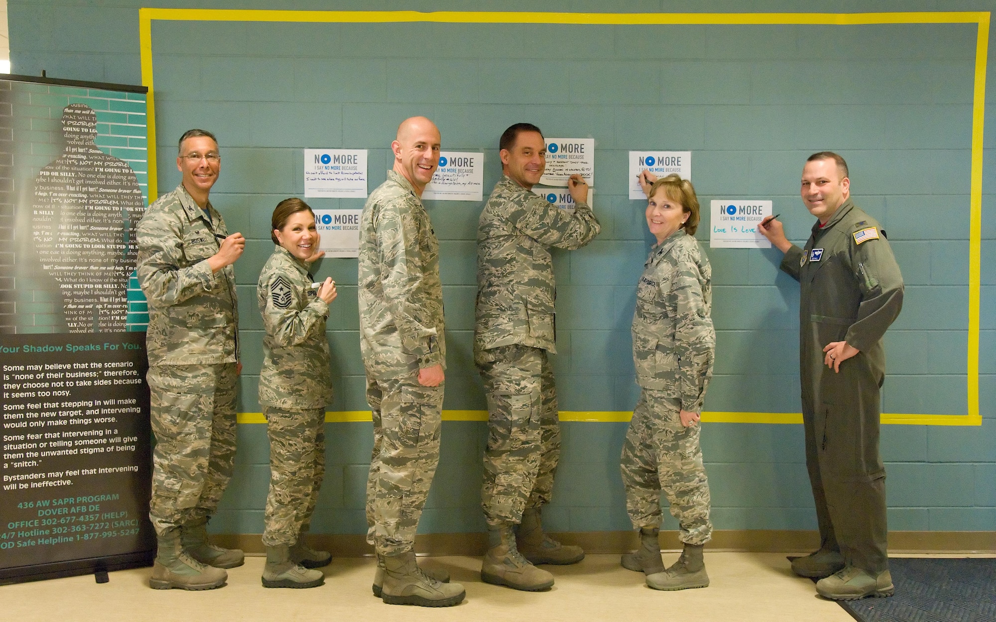 Team Dover senior leadership kicks off Sexual Assault Awareness Month by placing their campaign poster with a personal message on the graffiti wall March 31, 2017 at the Fitness Center on Dover Air Force Base, Del. Pictured left to right are Col. Randy Boswell, 436th Mission Support Group commander; Chief Master Sgt. Sarah Sparks, 436th Airlift Wing command chief; Col. Tyler Knack, 436th Maintenance Group commander; Col. Ethan Griffin, 436th AW commander; Col. Kathy Weiss, 436th Medical Group commander; and Col. Doug Hall, 436th Operations Group commander. Over 150 campaign posters were placed on the wall by the end of the first day. (U.S. Air Force photo by Roland Balik)