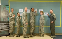 Team Dover senior leadership kicks off Sexual Assault Awareness Month by placing their campaign poster with a personal message on the graffiti wall March 31, 2017 at the Fitness Center on Dover Air Force Base, Del. Pictured left to right are Col. Randy Boswell, 436th Mission Support Group commander; Chief Master Sgt. Sarah Sparks, 436th Airlift Wing command chief; Col. Tyler Knack, 436th Maintenance Group commander; Col. Ethan Griffin, 436th AW commander; Col. Kathy Weiss, 436th Medical Group commander; and Col. Doug Hall, 436th Operations Group commander. Over 150 campaign posters were placed on the wall by the end of the first day. (U.S. Air Force photo by Roland Balik)