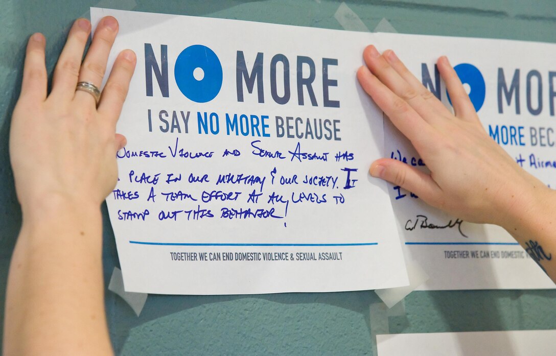 A Team Dover Volunteer Victim Advocate places a campaign poster on the graffiti wall during the Sexual Assault Awareness Month kick off event March 31, 2017 at the Fitness Center on Dover Air Force Base, Del. The Sexual Assault Prevention and Response office hosted this event, the first of many SAAM events scheduled during the month of April. (U.S. Air Force photo by Roland Balik)