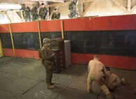 Close Quarters Battle instructors Sgt. Esteban Gutierrez and Staff Sgt. Corey Laird, Training Co., U.S. Marine Corps Security Force Regiment, demonstrate the proper way to maintain complete control of an occupant during Phase II, interior tactics, of the CQB course, Feb. 27, aboard Naval Support Activity Northwest Annex, Chesapeake, Va. The instructors stressed the importance of treating all occupants as a threat until deemed nonviolent, so they were better prepared to succeed during the final exercise, Operations Phase. (U.S. Marine Corps photo by Kayla D. Rivera/Released)