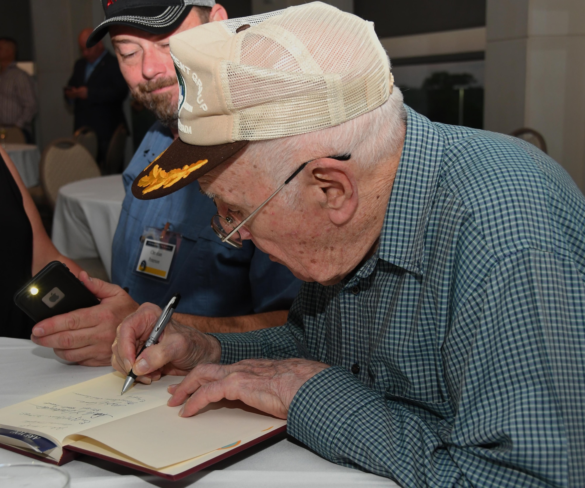 A 307th Bomb Wing alumni signs a book on the history of the 307th Bombardment Group during a reunion icebreaker event at the Shreveport Convention Center, Shreveport, La., March 30, 2017. The 307th BW hosted a reunion to celebrate the 75th anniversary of the unit and included alumni from wars such as World War II, the Korean War, Vietnam and the Cold War. (U.S. Air Force photo by Staff Sgt. Callie Ware/Released)