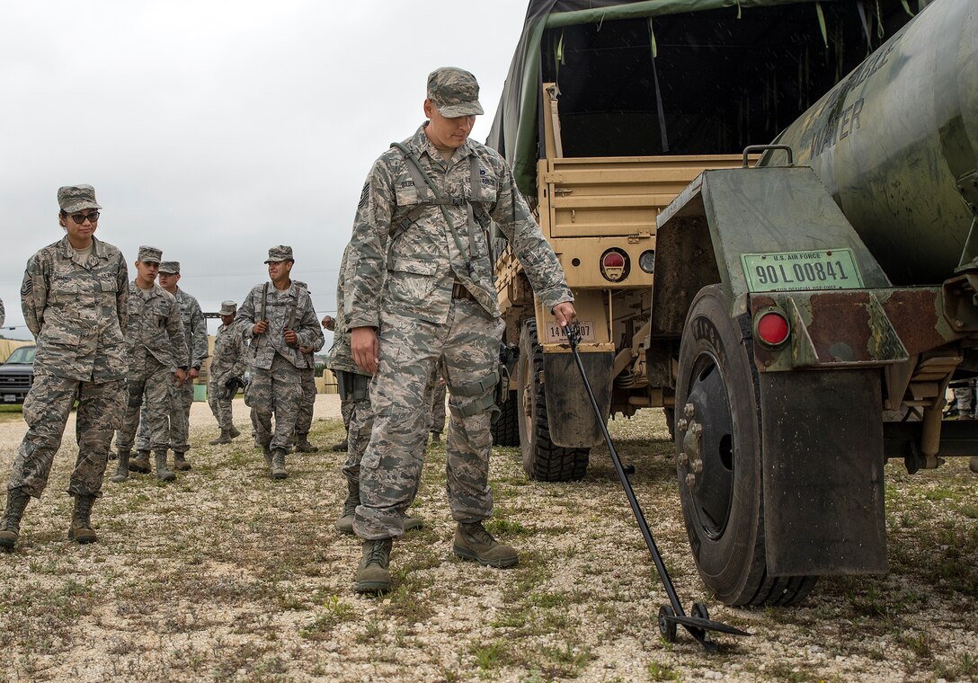 Tech. Sgt. Chase Guldenpfennig, 433rd Security Forces Squadron patrolman, inspects the underside of a water dispenser during vehicle search training at Training Base "Warrior" April 1, 2017 at Joint Base San Antonio-Camp Bullis, Texas. The 433rd SFS and 433rd Civil Engineering Squadron conducted a  six-block annual training regimen that included, application of force, tactics techniques and procedures, contingency patrol, movement, react to contact, and urban operations.  (U.S.  Air Force photo by Benjamin Faske)