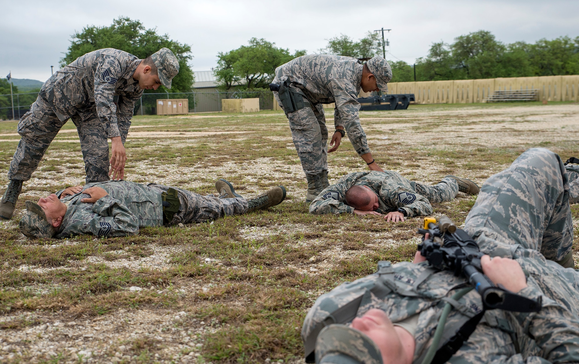 Airmen with the 433rd Security Forces and Civil Engineer Squadrons search enemy combatants for weapons during "React to Contact" training at Training Base "Warrior" April 1, 2017 at Joint Base San Antonio-Camp Bullis, Texas. The Airmen conducted a  six-block annual training regimen that included, application of force, tactics techniques and procedures, contingency patrol, movement, react to contact, and urban operations.  (U.S.  Air Force photo by Benjamin Faske)