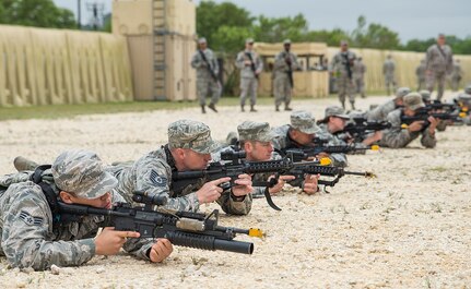 Airmen with the 433rd Security Forces and Civil Engineer Squadrons practice firing in formation during "Movement" training at Training Base "Warrior" April 1, 2017 at Joint Base San Antonio-Camp Bullis, Texas. The units conducted a  six-block annual training regimen that included, application of force, tactics techniques and procedures, contingency patrol, movement, react to contact, and urban operations.  (U.S.  Air Force photo by Benjamin Faske)