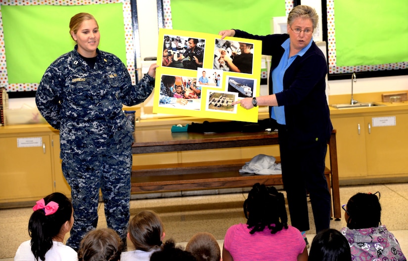 U.S. Navy Lt. Samantha Favreau, left,  Naval Health Clinic Charleston nurse, and Theresa Wood, right, NHCC Health and Wellness Department head, give a presentation to third graders at Marrington Elementary School March 27, 2017. Favreau and Wood highlighted the various aspects of their careers as Navy nurses and how they help community members live healthy lives. 