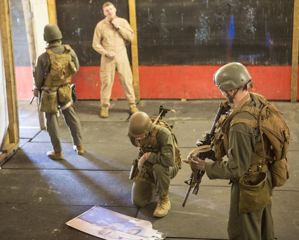 Students attending the Close Quarters Battle course aboard Naval Support Activity Northwest Annex, Chesapeake, Va., work together providing security in order to conduct a full-body search on a simulated occupant, Feb 27, during the interior tactics portion of tis course. This portion of the training prepared the Marines for the final exercise, Operations Phase, in order to properly take down live simulated occupants. (U.S. Marine Corps photo by Sgt. Kayla D. Rivera/Released.)