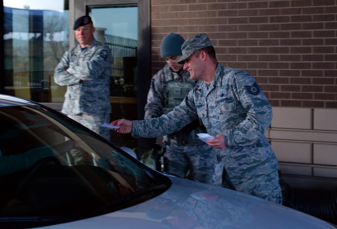Tech. Sgt. Gideon Stibor, a fuels management flight section chief assigned to the 28th Logistic Readiness Squadron, gives a Sexual Assault Awareness and Prevention Month pamphlet to personnel at the Liberty Gate on Ellsworth Air Force Base, S.D., March 31, 2017. The Ellsworth Sexual Assault Response Coordinator established static and interactive display booths throughout the installation to highlight April as sexual assault awareness and prevention month.  (U.S. Air Force photo by Airman Nicolas Z. Erwin)
