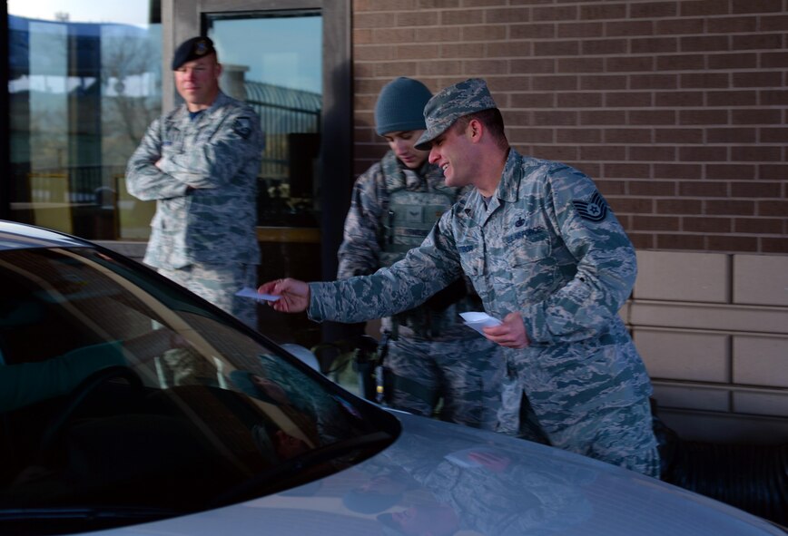 Tech. Sgt. Gideon Stibor, a fuels management flight section chief assigned to the 28th Logistic Readiness Squadron, gives a Sexual Assault Awareness and Prevention Month pamphlet to personnel at the Liberty Gate on Ellsworth Air Force Base, S.D., March 31, 2017. The Ellsworth Sexual Assault Response Coordinator established static and interactive display booths throughout the installation to highlight April as sexual assault awareness and prevention month.  (U.S. Air Force photo by Airman Nicolas Z. Erwin)