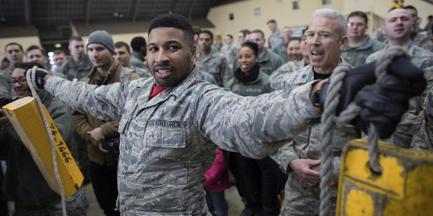 Senior Airman Quentin Gartrell, 374th Maintenance Group document specialist, holds chocks up over 30 seconds during the annual 374th MXG wrenchbender rodeo chock hold competition at Yokota Air Base, Japan, March 31, 2017. The chock hold competition challenged Airmen to endure holding chocks up longer than opposing teams. A chock is a wedge placed against a wheel to prevent an aircraft from movement. (U.S. Air Force photo by Yasuo Osakabe)