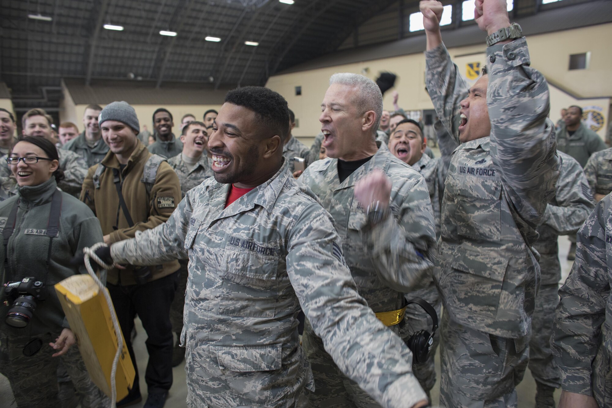 Senior Airman Quentin Gartrell, 374th Maintenance Group document specialist, laughs as he wins the competition during the annual 374th Maintenance Group wrenchbender rodeo chock hold competition at Yokota Air Base, Japan, March 31, 2017. The chock hold competition challenged Airmen to endure holding chocks up longer than opposing teams. A chock is a wedge placed against a wheel to prevent an aircraft from movement. (U.S. Air Force photo by Yasuo Osakabe)