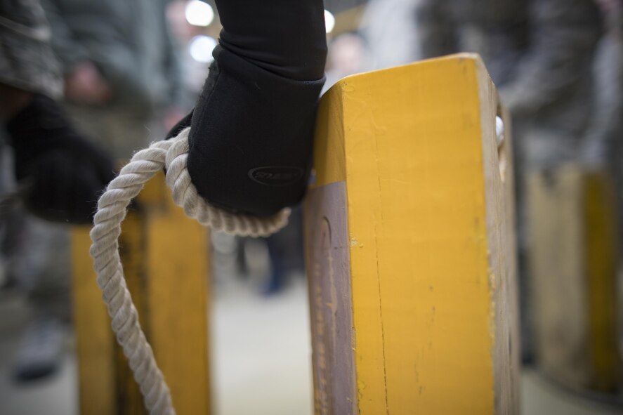 Senior Airman Anthony Trim, 374th Aircraft Maintenance Squadron crew chief, prepares to hold up chocks during the annual 374th Maintenance Group Wrenchbender rodeo chock hold competition at Yokota Air Base, Japan, March 31, 2017. Trim is one of the finalist of the competition. The chock hold competition challenged Airmen to endure holding chocks up longer than opposing teams. A chock is a wedge placed against a wheel to prevent an aircraft from movement. (U.S. Air Force photo by Yasuo Osakabe) 