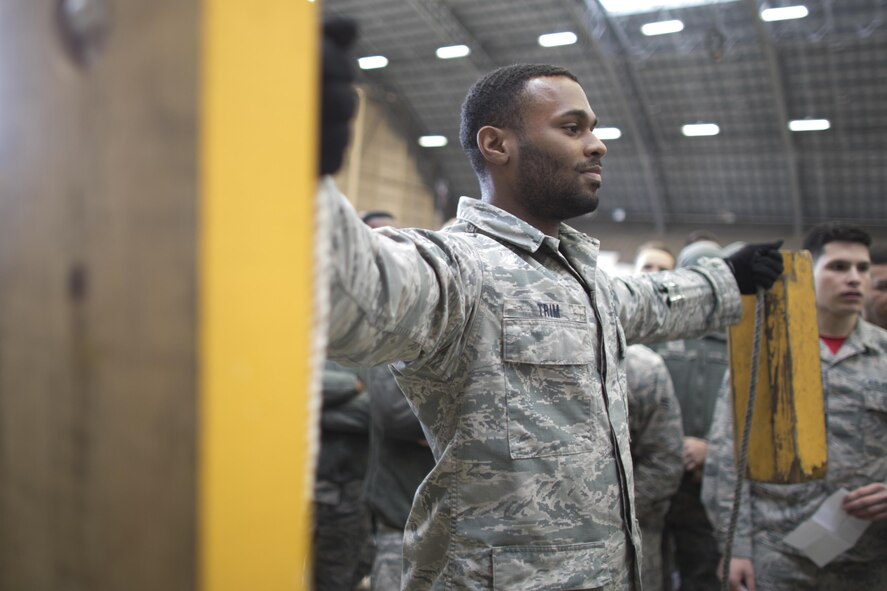 Senior Airman Anthony Trim, 374th Aircraft Maintenance Squadron crew chief, holds chocks up during the annual 374th Maintenance Group Wrenchbender rodeo chock hold competition at Yokota Air Base, Japan, March 31, 2017. Trim is one of the finalist of the competition. The chock hold competition challenged Airmen to endure holding chocks up longer than opposing teams. A chock is a wedge placed against a wheel to prevent an aircraft from movement. (U.S. Air Force photo by Yasuo Osakabe)
