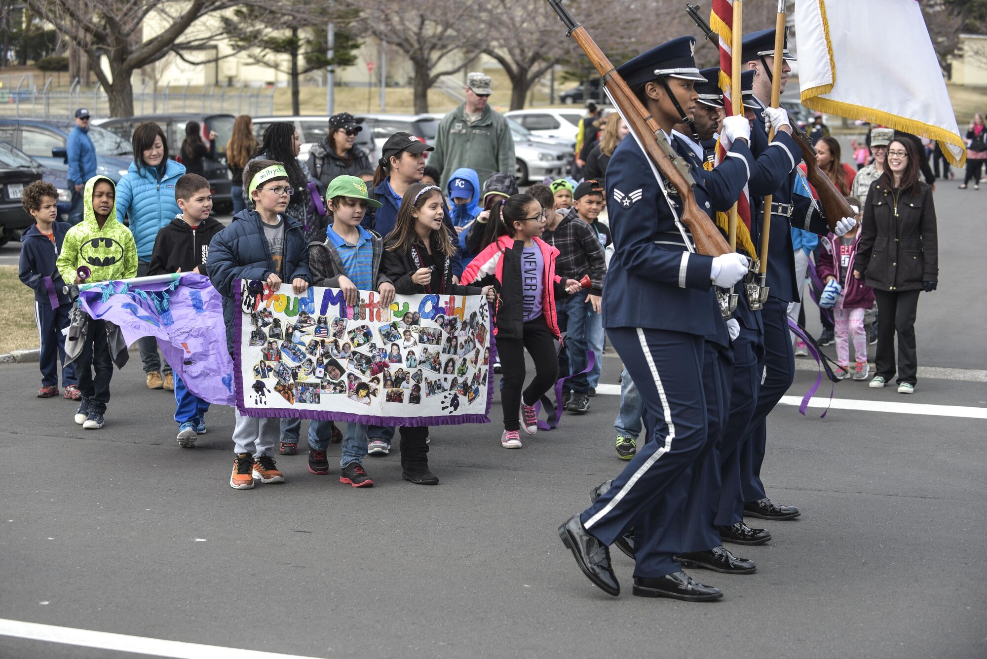 Misawa Honor Guardsmen lead children, parents and staff from the Yoiko Child Development Center in the Month of the Military Child parade at Misawa Air Base, Japan, April 3, 2017. The parade featured members of the base honor guard, the fire department mascot Sparky and posters made by the CDC staff and children. (U.S. Air Force photo by Staff Sgt. Melanie A. Hutto)