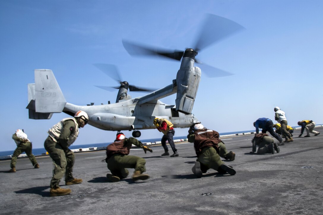 Sailors and Marines brace against rotor wash as an MV-22B Osprey takes off from the USS Bonhomme Richard's flight deck in the East China Sea, April 4, 2017. The Bonhomme Richard is on a routine patrol in the Indo-Asia-Pacific region. Navy photo by Petty Officer 2nd Class Diana Quinlan