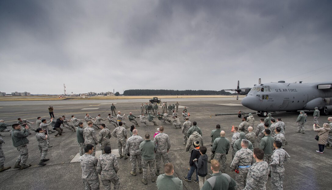 A crowd cheers on members of the 374th Maintenance Group as they pull a C-130H Hercules down the runway during the 374th Maintenance Group Wrenchbender Rodeo March 31, 2017, at Yokota Air Base, Japan. Over 400 Airmen gathered on the flightline for the Wrenchbender Rodeo hosted by the 374th Maintenance Group. (U.S. Air Force photo by Airman 1st Class Donald Hudson)